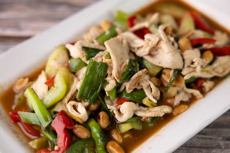 A vibrant plate of chicken stir-fry with vegetables and peanuts, featuring the bold flavors of Thai food Albuquerque, a favorite at Thai Boran Restaurant.